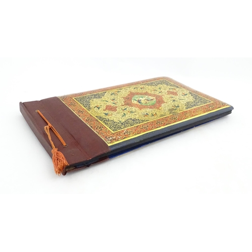 2122 - A Persian photograph album with lacquered boards, one decorated with an enamel panel depicting birds... 