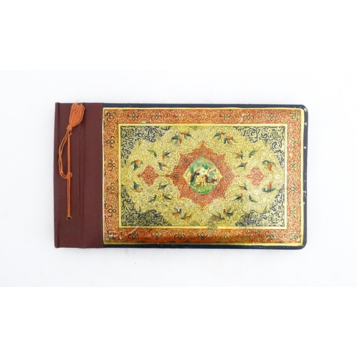 2122 - A Persian photograph album with lacquered boards, one decorated with an enamel panel depicting birds... 