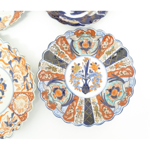 59 - Four Japanese chargers with shaped edges decorated in the Imari palette with flowers, foliage and bi... 