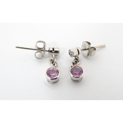 733A - A pair of white gold drop earrings set with diamonds with pink sapphire drops. Approx. 1/2