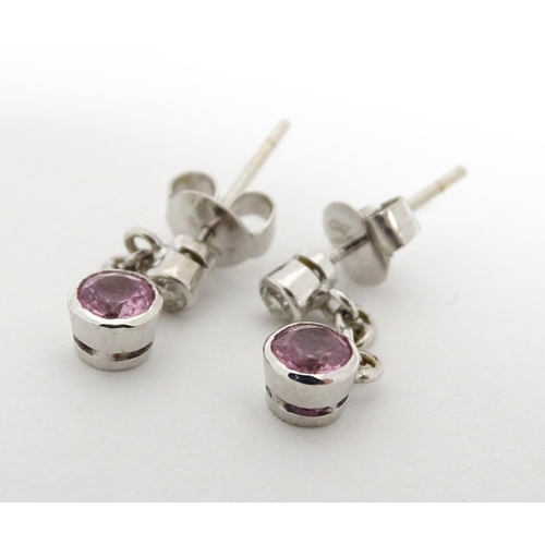 733A - A pair of white gold drop earrings set with diamonds with pink sapphire drops. Approx. 1/2