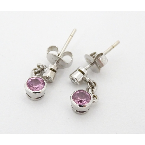 733A - A pair of white gold drop earrings set with diamonds with pink sapphire drops. Approx. 1/2