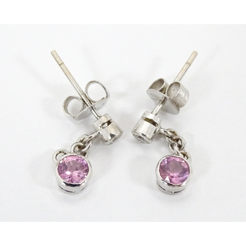 733A - A pair of white gold drop earrings set with diamonds with pink sapphire drops. Approx. 1/2