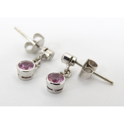 733A - A pair of white gold drop earrings set with diamonds with pink sapphire drops. Approx. 1/2