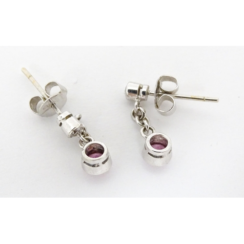 733A - A pair of white gold drop earrings set with diamonds with pink sapphire drops. Approx. 1/2