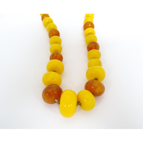 760A - A vintage necklace of graduated amber beads. Approx 24