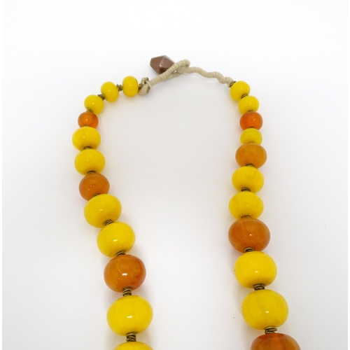 760A - A vintage necklace of graduated amber beads. Approx 24