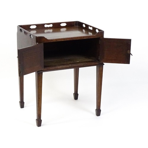 1491 - An 18thC mahogany bedside table / tray top cabinet with a pierced upstand above two hinged doors and... 