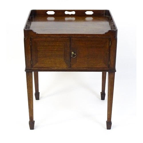 1491 - An 18thC mahogany bedside table / tray top cabinet with a pierced upstand above two hinged doors and... 