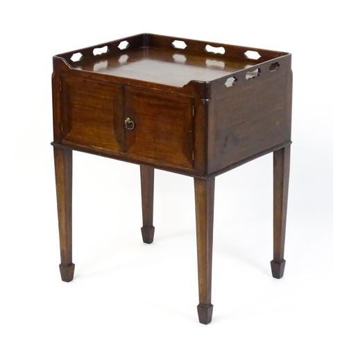 1491 - An 18thC mahogany bedside table / tray top cabinet with a pierced upstand above two hinged doors and... 