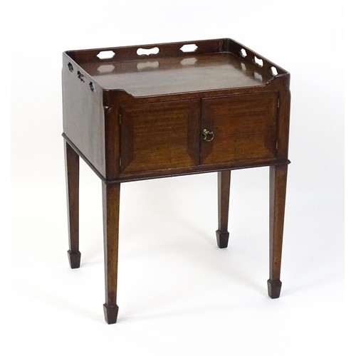 1491 - An 18thC mahogany bedside table / tray top cabinet with a pierced upstand above two hinged doors and... 