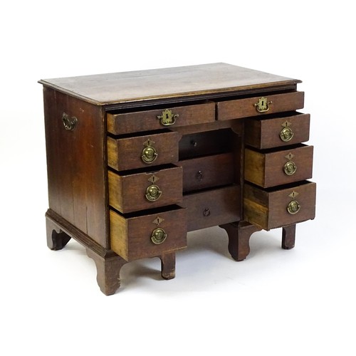 1510 - An early / mid 18thC oak kneehole desk with a moulded top above two short drawers and two banks of f... 