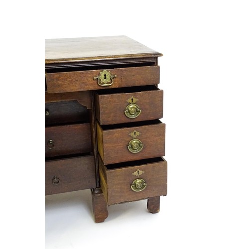 1510 - An early / mid 18thC oak kneehole desk with a moulded top above two short drawers and two banks of f... 