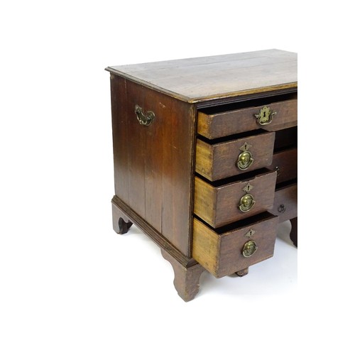 1510 - An early / mid 18thC oak kneehole desk with a moulded top above two short drawers and two banks of f... 