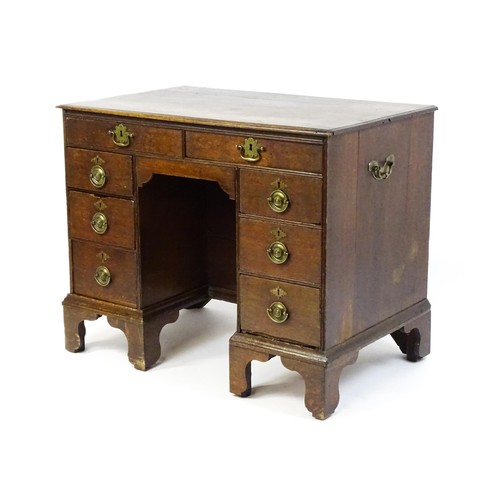 1510 - An early / mid 18thC oak kneehole desk with a moulded top above two short drawers and two banks of f... 