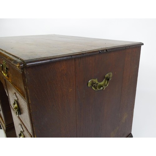 1510 - An early / mid 18thC oak kneehole desk with a moulded top above two short drawers and two banks of f... 