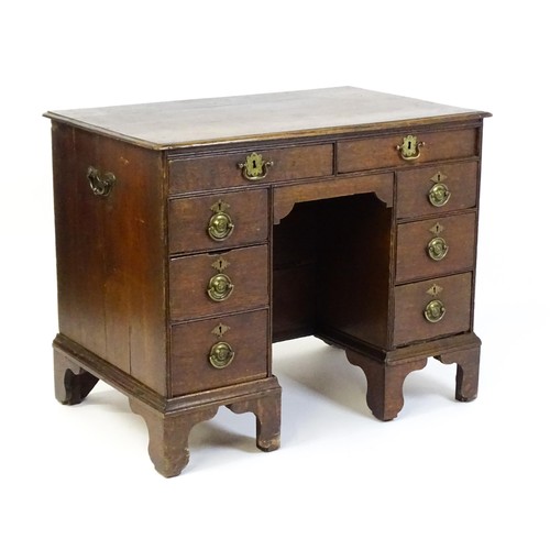 1510 - An early / mid 18thC oak kneehole desk with a moulded top above two short drawers and two banks of f... 