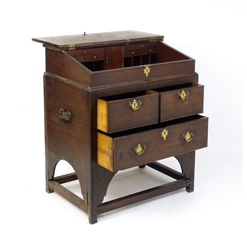 1511 - An early / mid 18thC mahogany clerks desk with a hinged sloping lid opening to show a fitted interio... 