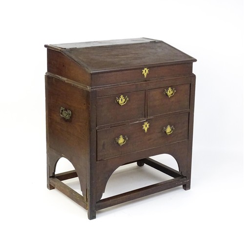 1511 - An early / mid 18thC mahogany clerks desk with a hinged sloping lid opening to show a fitted interio... 