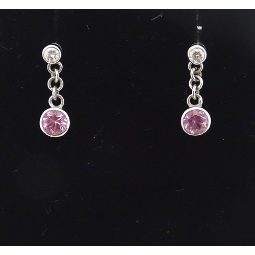 733A - A pair of white gold drop earrings set with diamonds with pink sapphire drops. Approx. 1/2