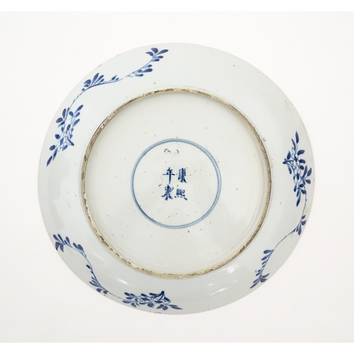 4 - A Chinese blue and white plate decorated with central taihu rock and flowers, bordered by figures in... 