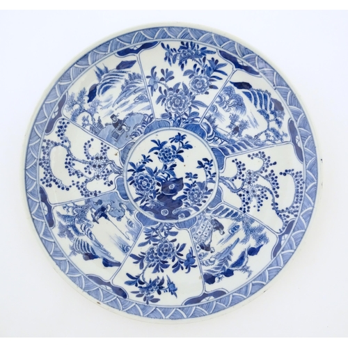 4 - A Chinese blue and white plate decorated with central taihu rock and flowers, bordered by figures in... 