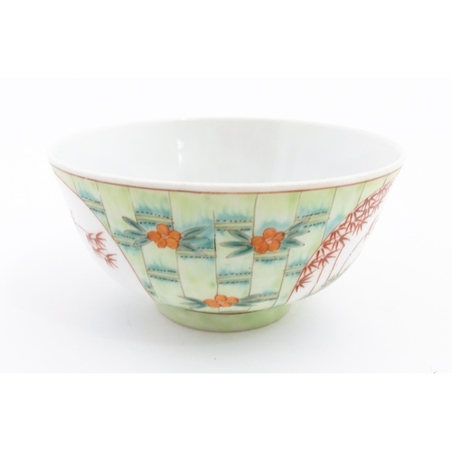 16 - A Chinese famille verte bowl decorated with stylised bamboo and flowers. Character marks under. Appr... 