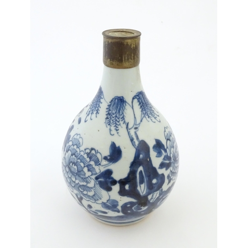 18 - A Chinese blue and white bottle vase decorated with flowers and foliage, with a metal mount. Approx.... 