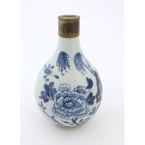 18 - A Chinese blue and white bottle vase decorated with flowers and foliage, with a metal mount. Approx.... 