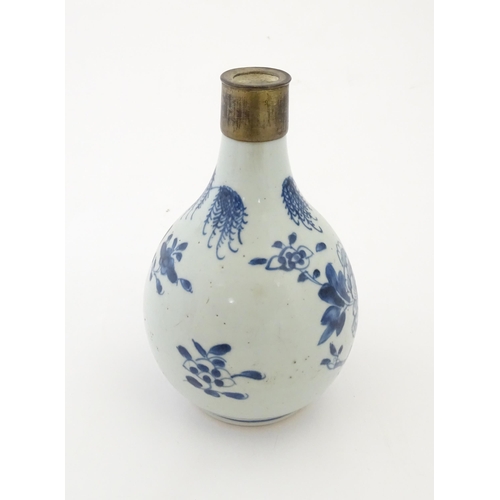 18 - A Chinese blue and white bottle vase decorated with flowers and foliage, with a metal mount. Approx.... 