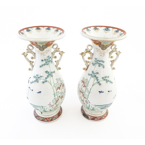 24 - A pair of Japanese vases with flared rim and twin handles, decorated with a vignette depicting figur... 