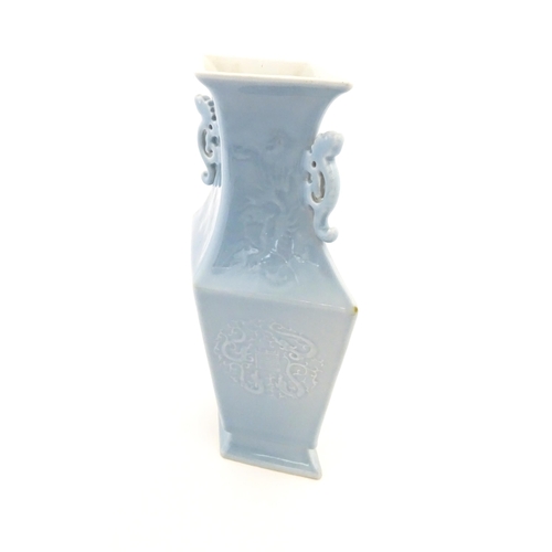 25 - A Chinese vase of angular baluster form with a pale blue ground and twin handles, decorated with pho... 