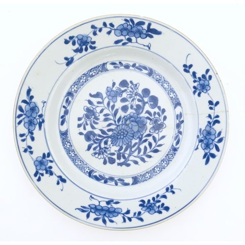 30 - A Chinese blue and white plate decorated with flowers and foliage, with brushwork detail to reverse.... 