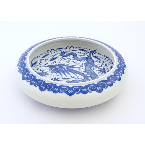 47 - A Chinese blue and white bowl / dish decorated with a dragon and flaming pearl amongst stylised clou... 