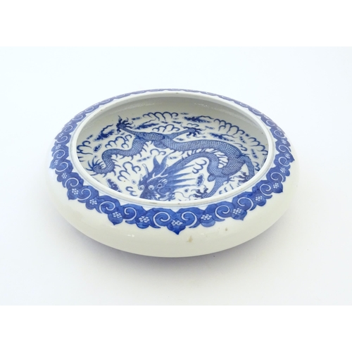 47 - A Chinese blue and white bowl / dish decorated with a dragon and flaming pearl amongst stylised clou... 