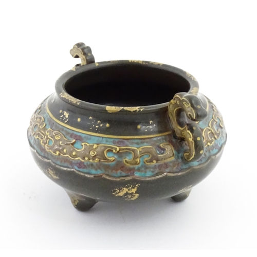 48 - A small Chinese censer with twin handles with banded decoration in relief depicting stylised dragons... 