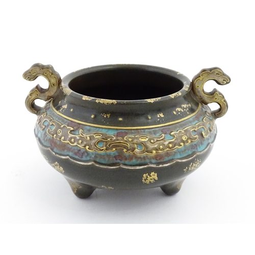 48 - A small Chinese censer with twin handles with banded decoration in relief depicting stylised dragons... 