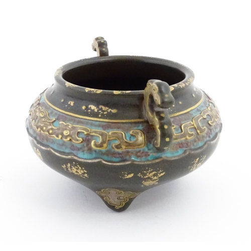 48 - A small Chinese censer with twin handles with banded decoration in relief depicting stylised dragons... 