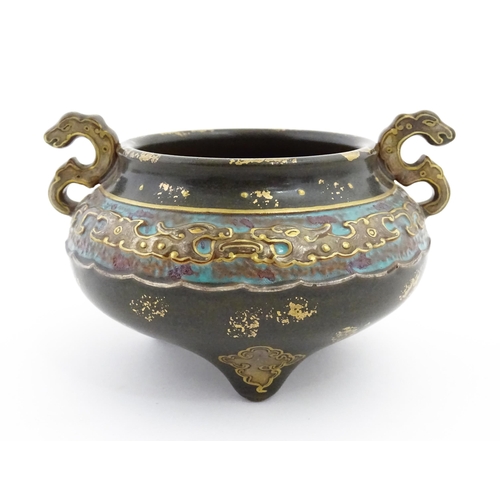 48 - A small Chinese censer with twin handles with banded decoration in relief depicting stylised dragons... 