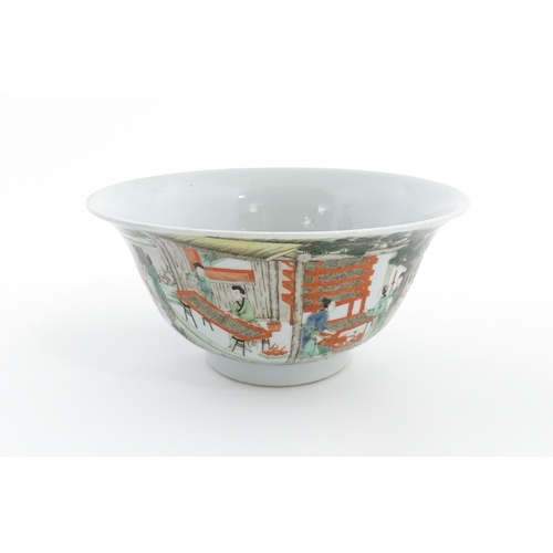 49 - A Chinese famille verte bowl decorated with figures harvesting grain, the centre with a figure shooi... 