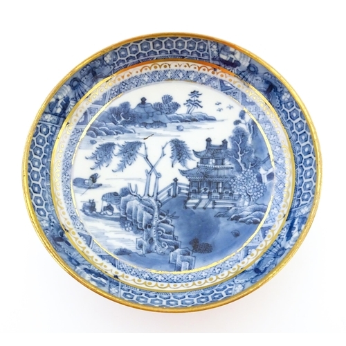 74 - A blue and white dish with hand painted chinoiserie river scene with figures in boats by a pagoda st... 