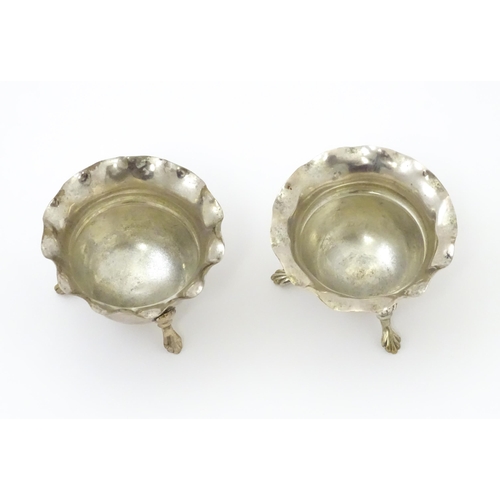 334 - A pair of silver salts with crimped rims and raised on 3 paw feet. Hallmarked Birmingham 1931 maker ... 