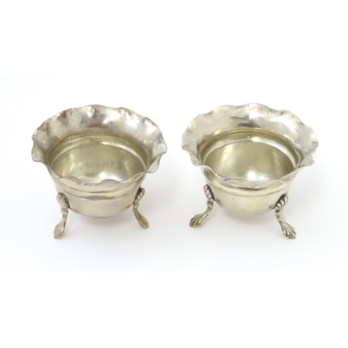 334 - A pair of silver salts with crimped rims and raised on 3 paw feet. Hallmarked Birmingham 1931 maker ... 