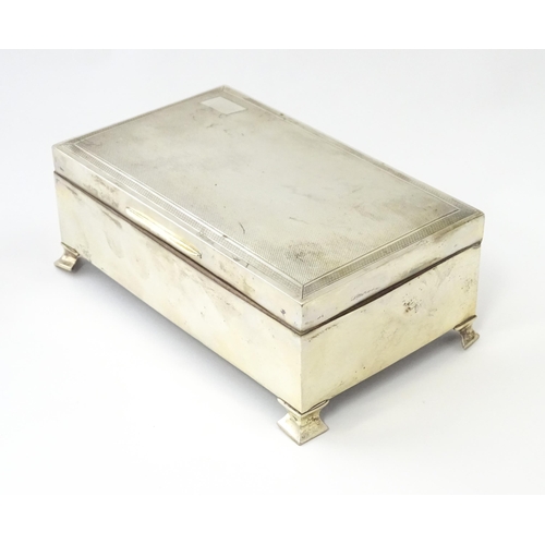 239 - A silver table top cigarette box with engine turned decoration opening to reveal a cedar lined inter... 