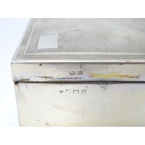 239 - A silver table top cigarette box with engine turned decoration opening to reveal a cedar lined inter... 