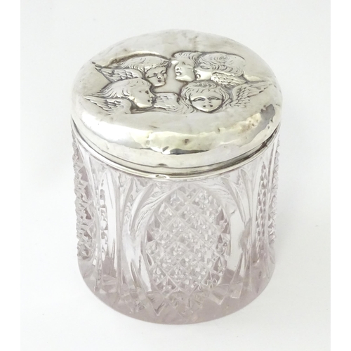 240 - A cut glass dressing table jar with silver top with embossed angel detail, hallmarked Birmingham 190... 