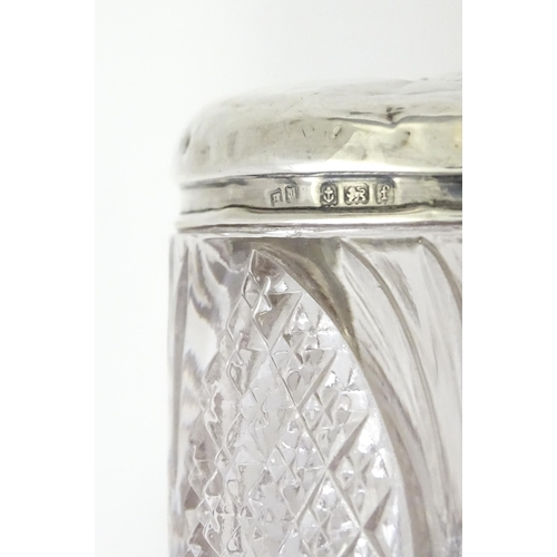 240 - A cut glass dressing table jar with silver top with embossed angel detail, hallmarked Birmingham 190... 