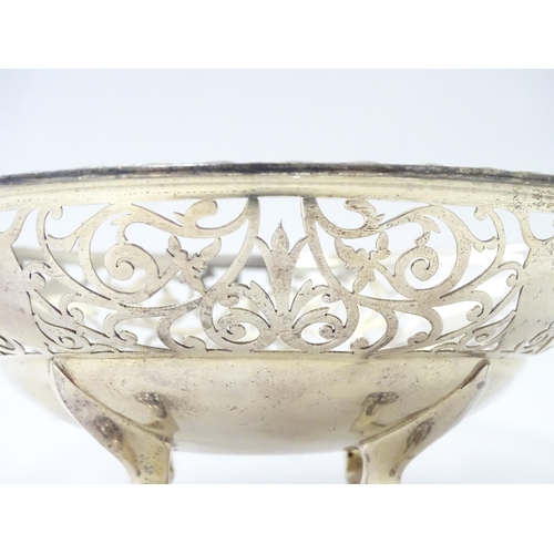 244 - A large silver bon bon dish / fruit dish with pierced scroll detail, standing on four lion paw feet,... 