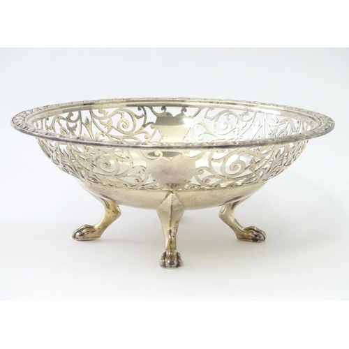 244 - A large silver bon bon dish / fruit dish with pierced scroll detail, standing on four lion paw feet,... 