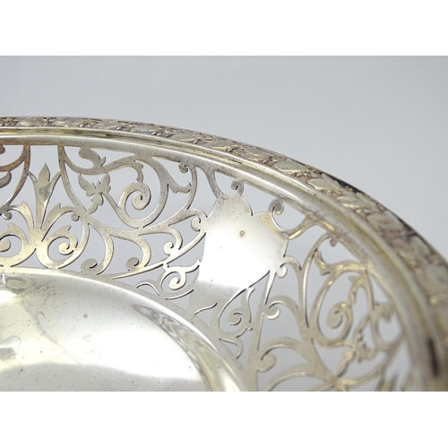 244 - A large silver bon bon dish / fruit dish with pierced scroll detail, standing on four lion paw feet,... 